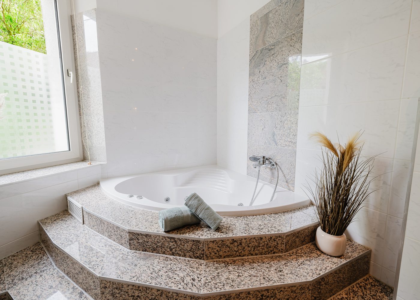 Badezimmer des Altbautraums in Braunschweig mit Eckbadewanne und Tageslicht