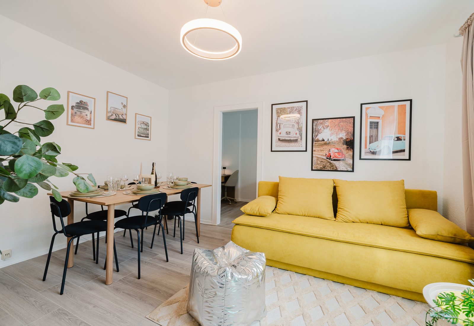 Wohn- und Essbereich des Beetle Apartments mit gelbem Sofa
