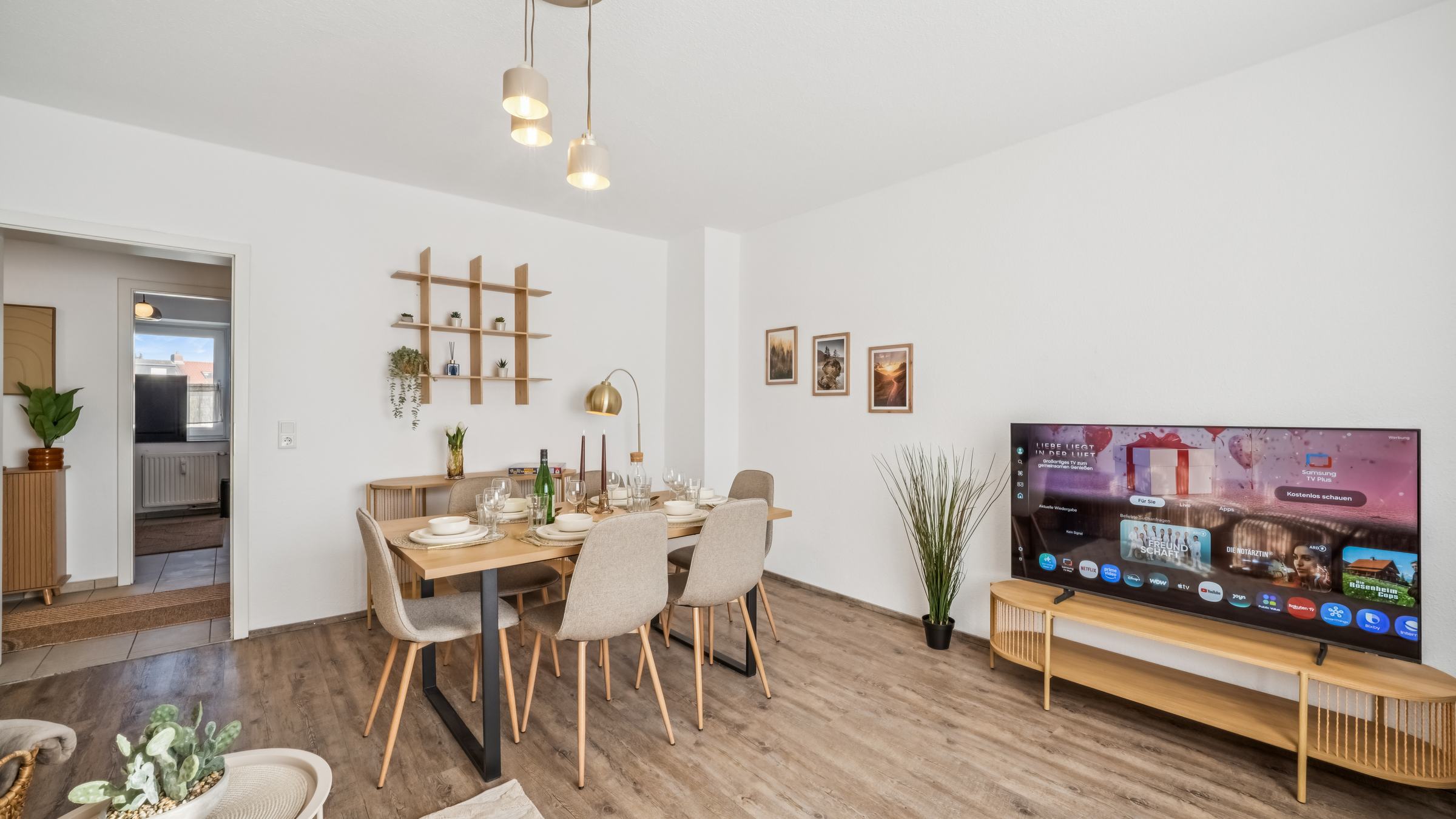 Wohn- und Essbereich des Luana Design Apartments mit Sofa, Esstisch und Holzdielen