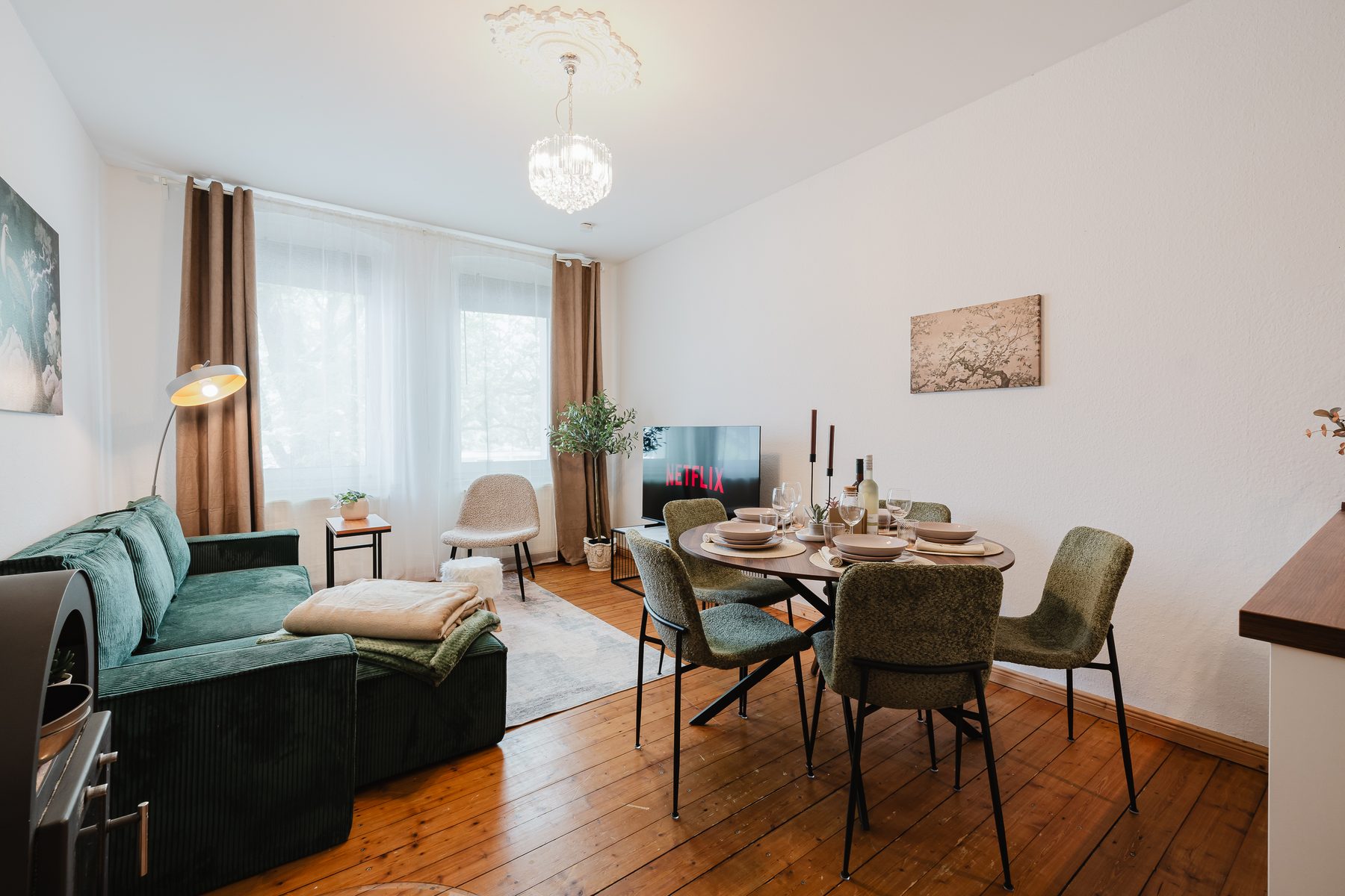 Wohn- und Essbereich mit grünem Sofa und Esstisch