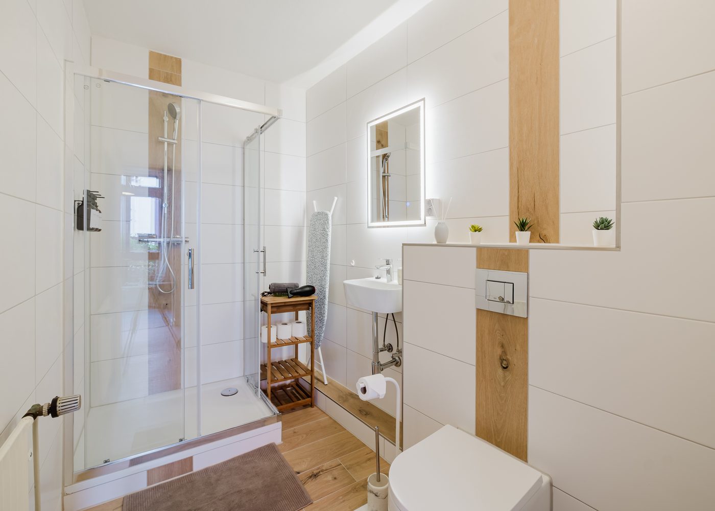 Neues Badezimmer des Kirchenblick-Lofts mit Glasdusche, Waschbecken und Holzakzenten