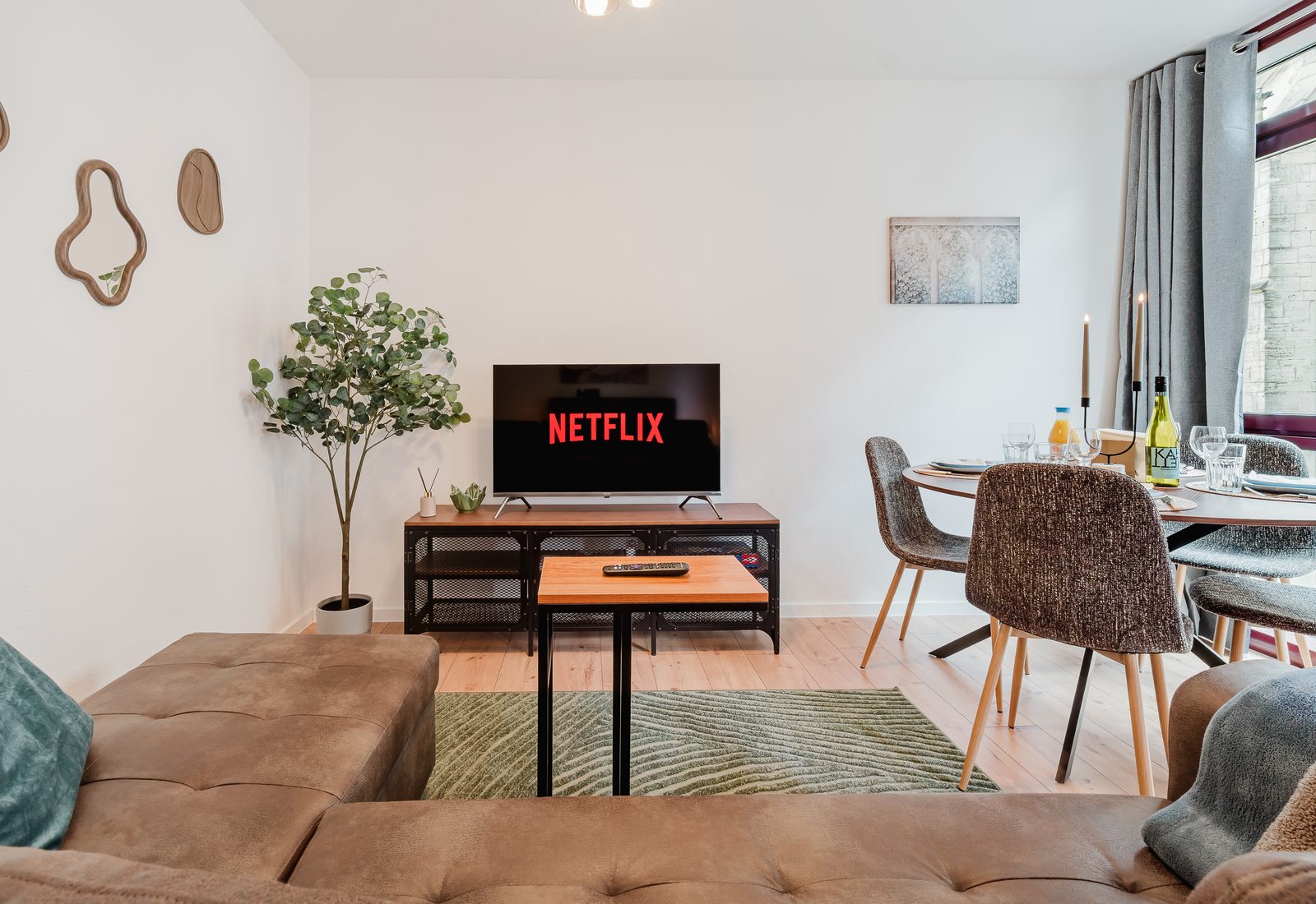 Wohn- und Essbereich des Kirchenblick-Lofts mit Ledersofa, Smart-TV und Esstisch