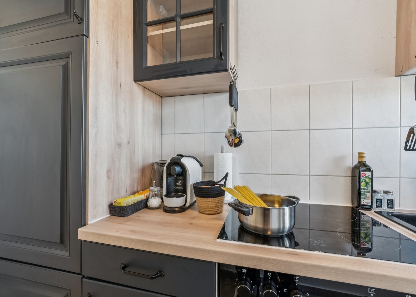 Küche des Luana Design Apartments in Braunschweig mit dunklen Fronten und Holzarbeitsplatte
