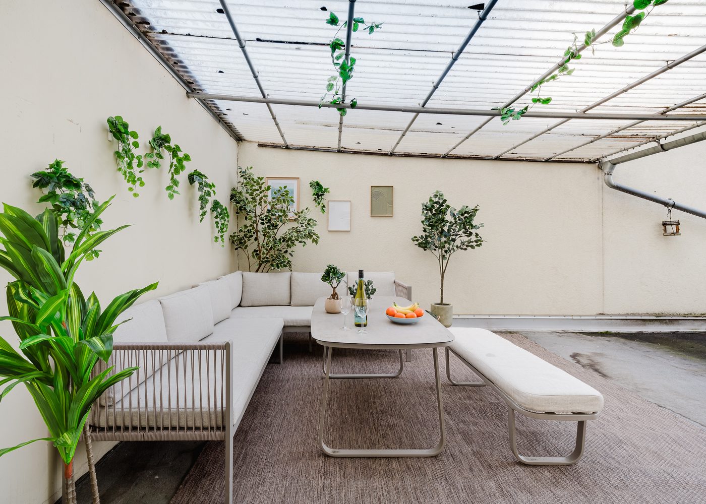 Überdachte Dachterrasse des Stadtjuwels mit Lounge-Ecke, Sitzbank und vielen Pflanzen